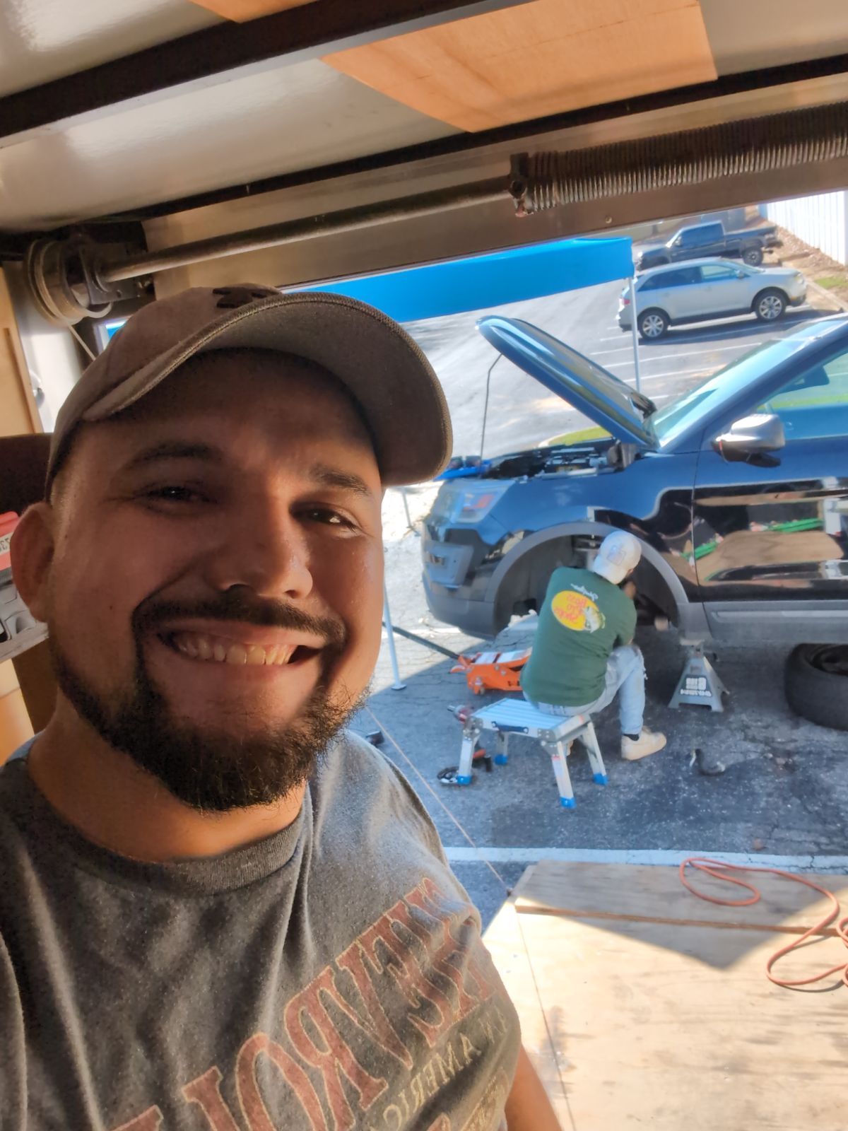 Two men are working on the engine of a car.