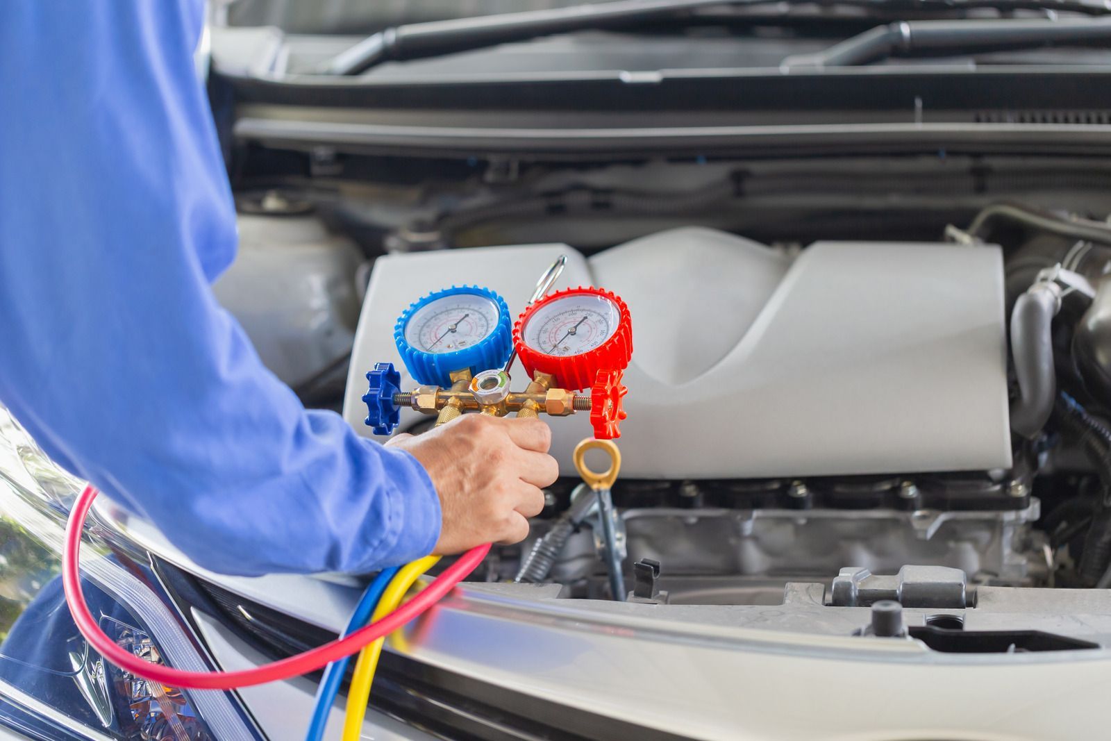 A man is working on the engine of a car.