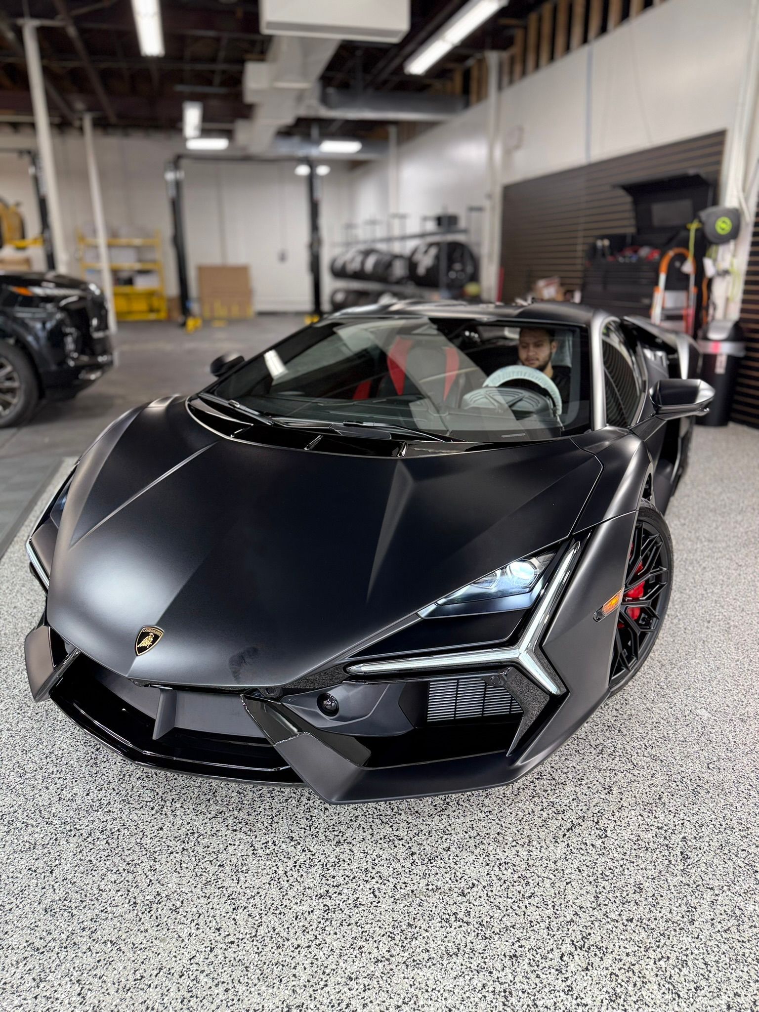 Black Lamborghini in a garage.