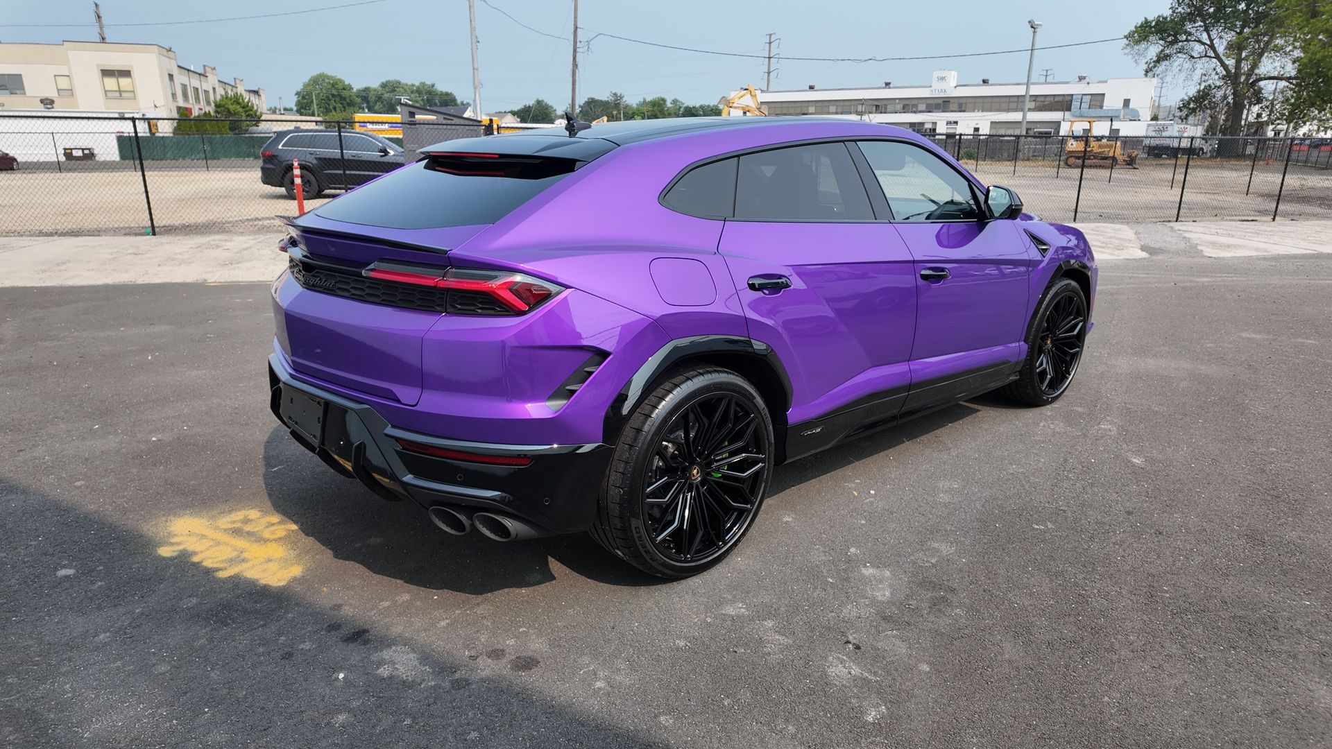 Purple Lamborghini SUV parked on pavement.