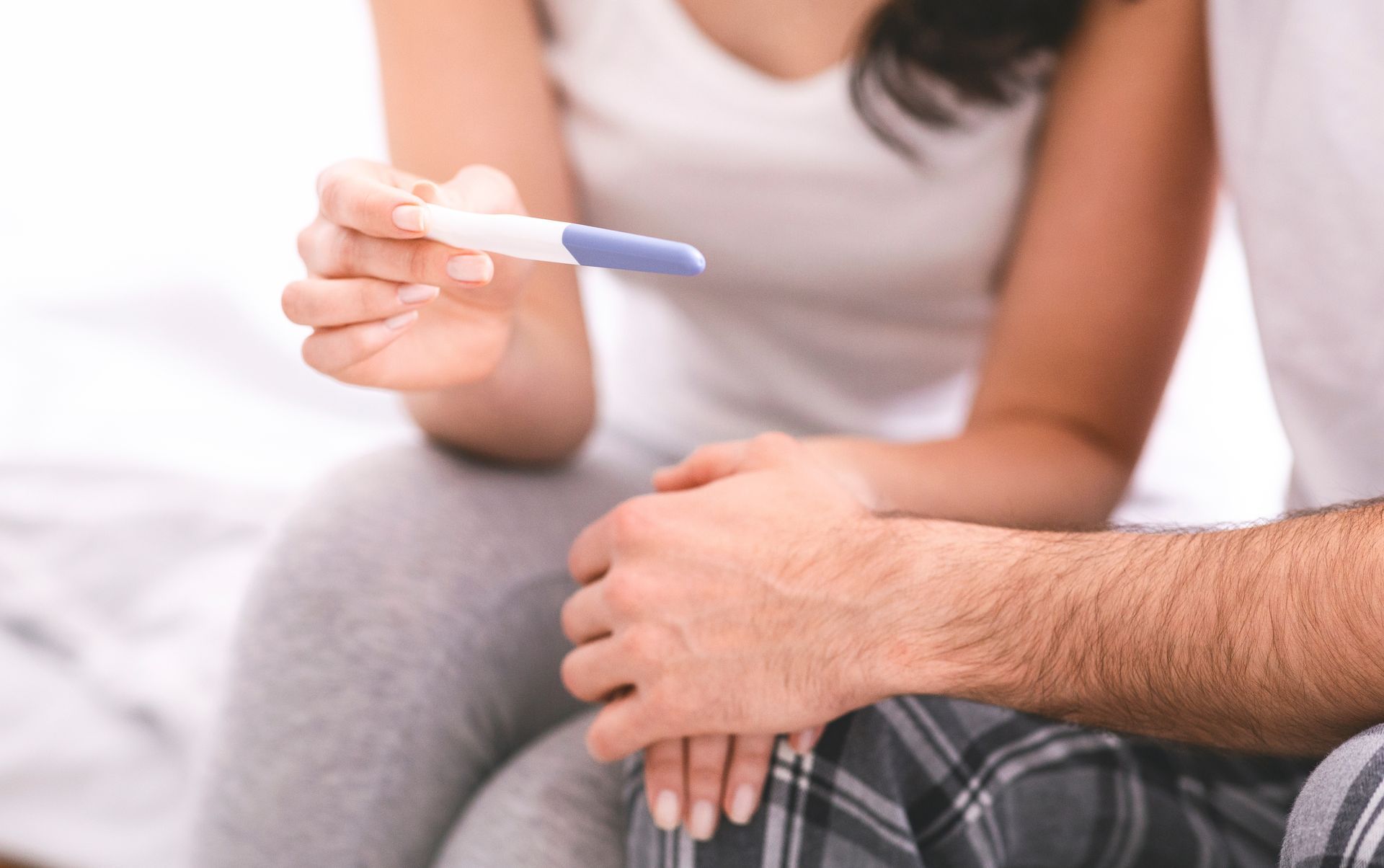 Worried man and woman waiting for result of pregnancy test.