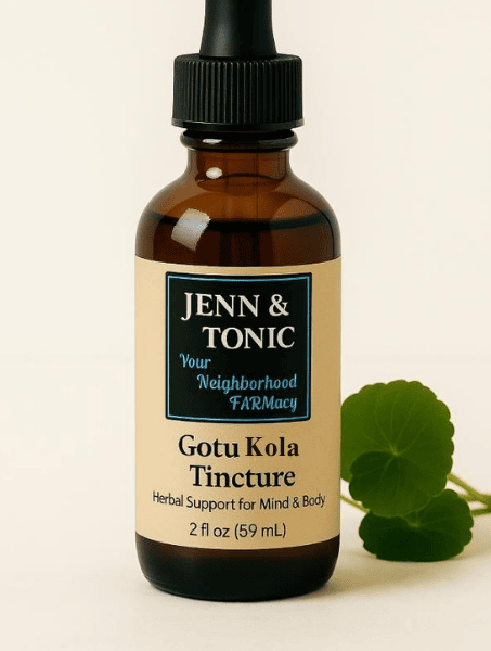 A bottle of Jenn & Tonic Gotu Kola Tincture with a dropper cap, standing next to a small green plant leaf.