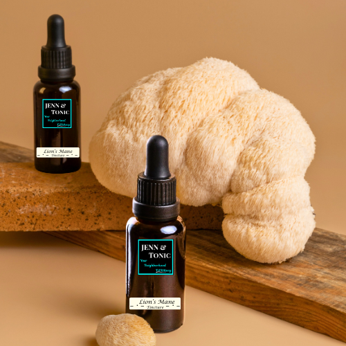 Two bottles of jenn & tonic next to a lion's mane mushroom