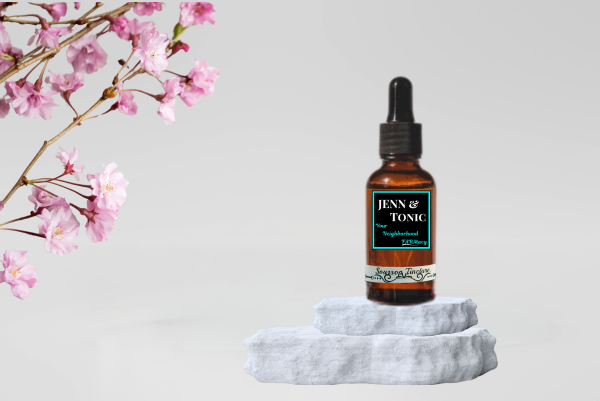 A dropper bottle of Soursop tincture is sitting on a podium in front of a cherry blossom tree.