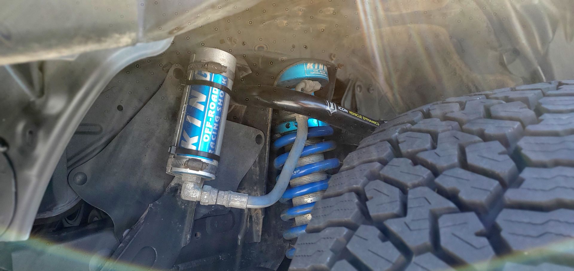 A close up of a shock absorber and a tire on a car | Griffin Motorwerke