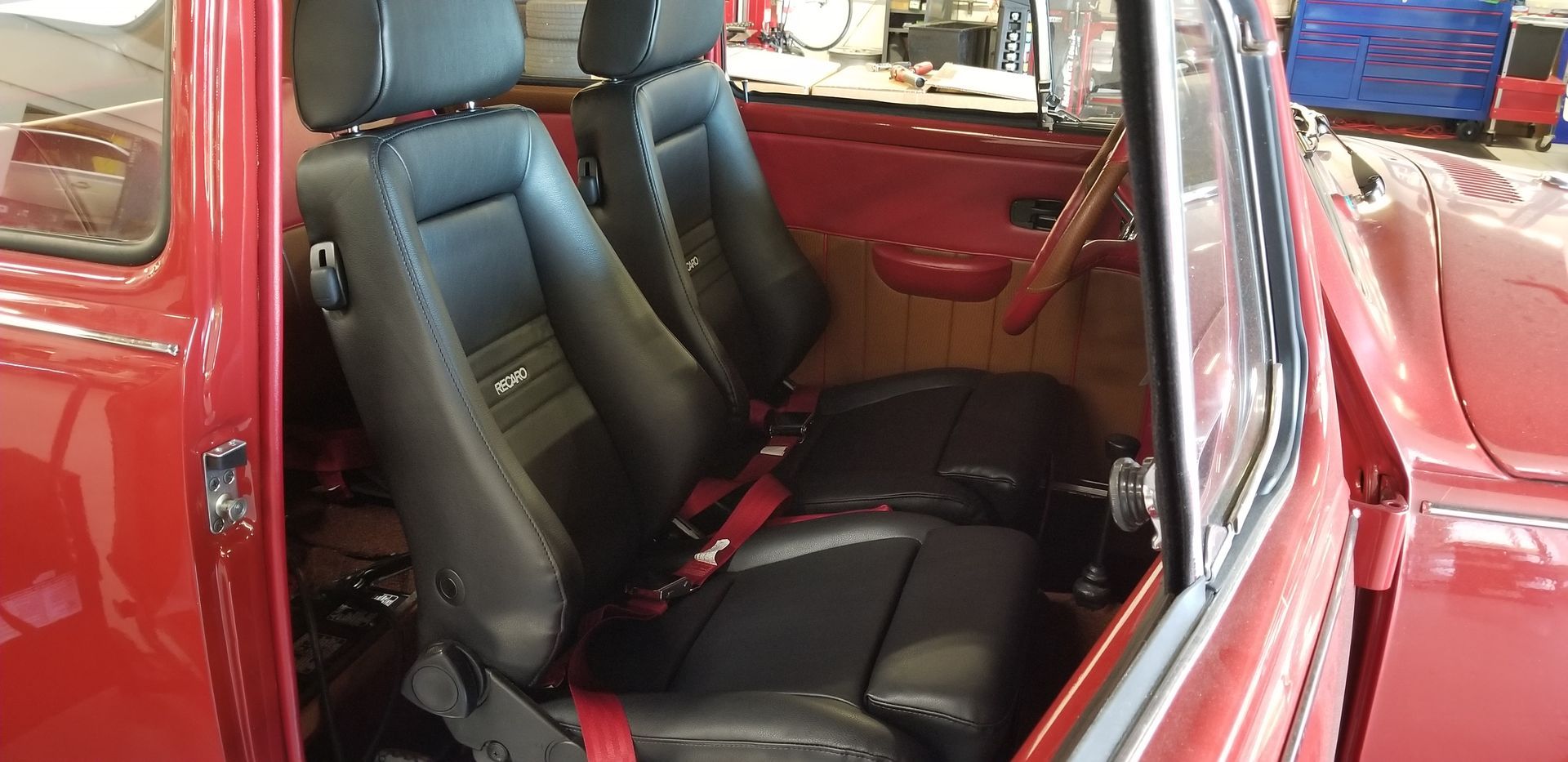 The inside of a red car with black leather seats | Griffin Motorwerke