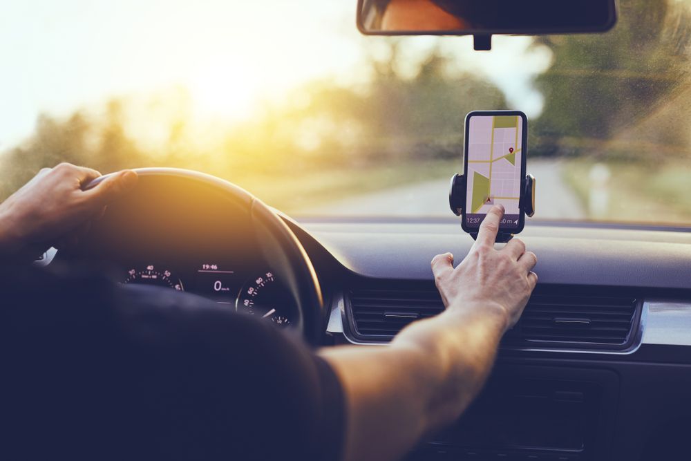 Driver Using GPS Navigation In Mobile Phone While Driving Car