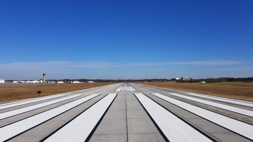 Runway with white markings, blue sky.