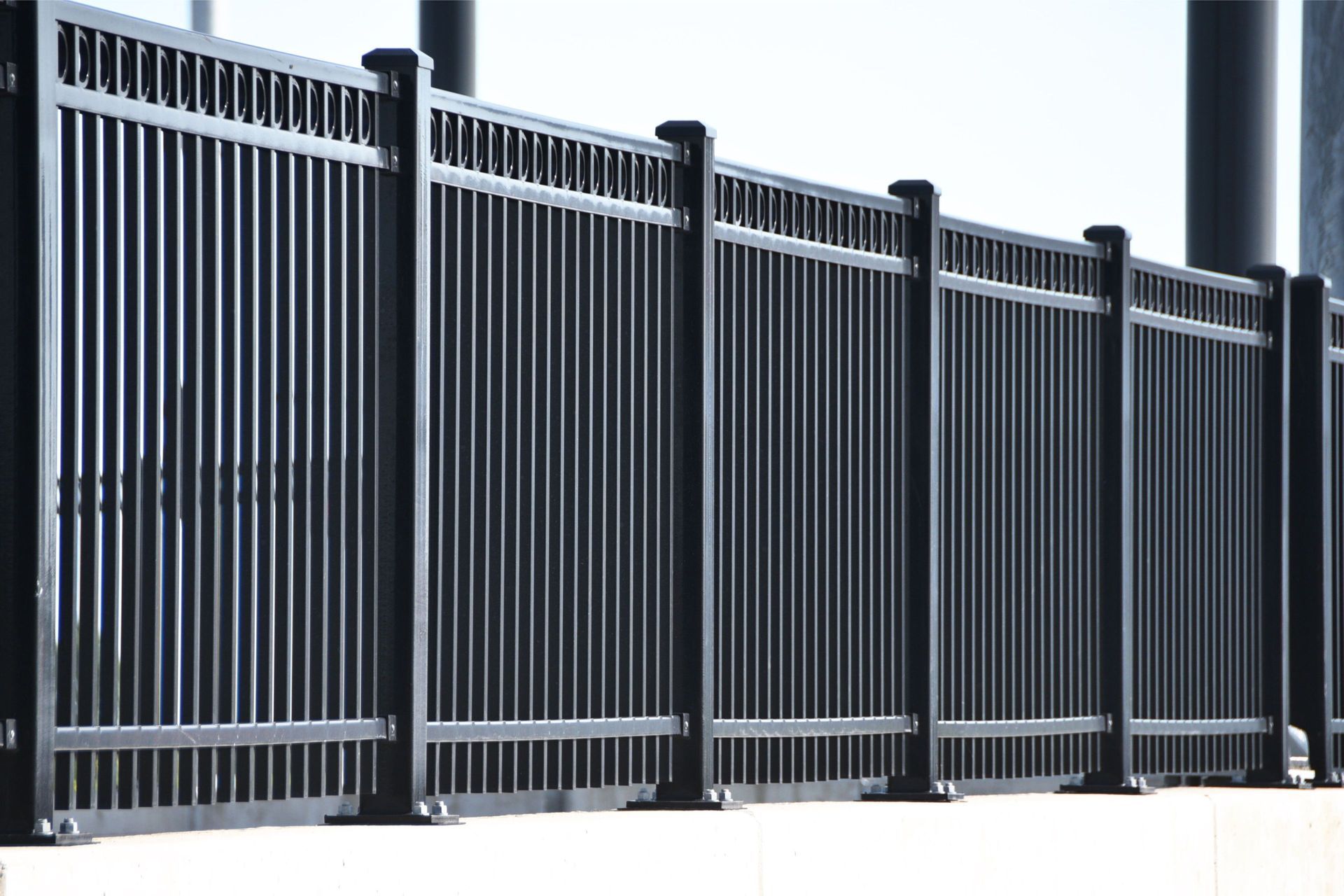 Black metal fence with vertical bars, likely for a balcony or border.