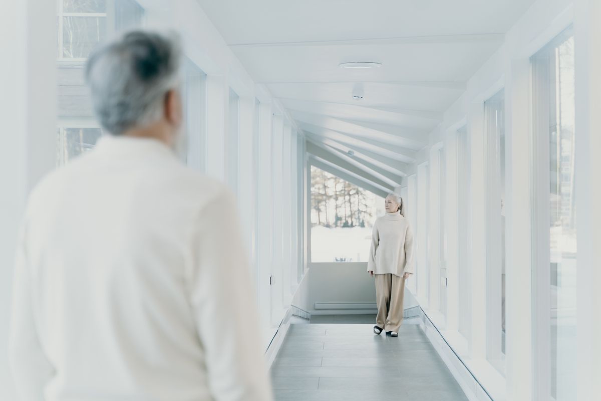 Active older adults walking together through a bright indoor hallway