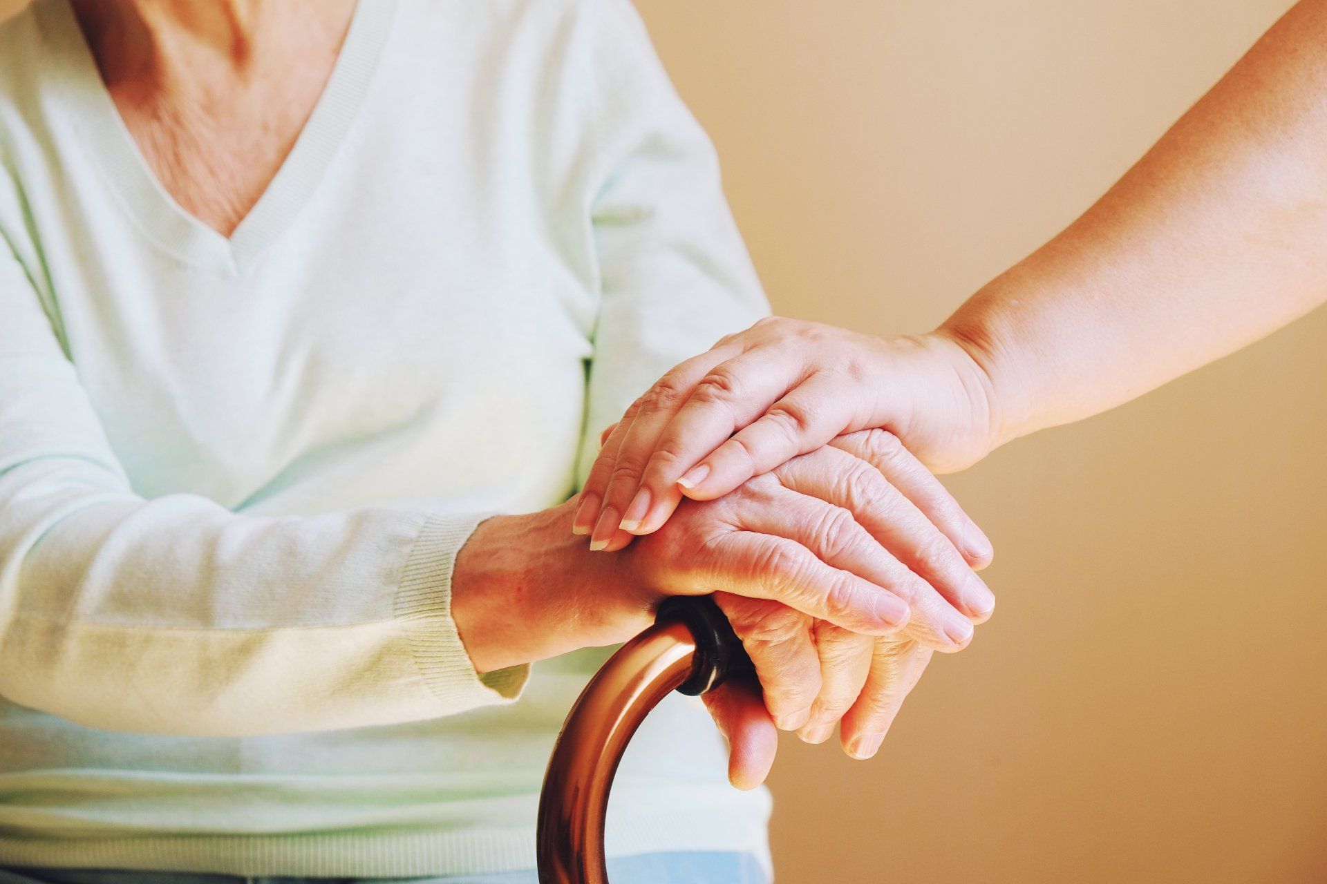 Caregiver supporting an older woman at home during a conversation