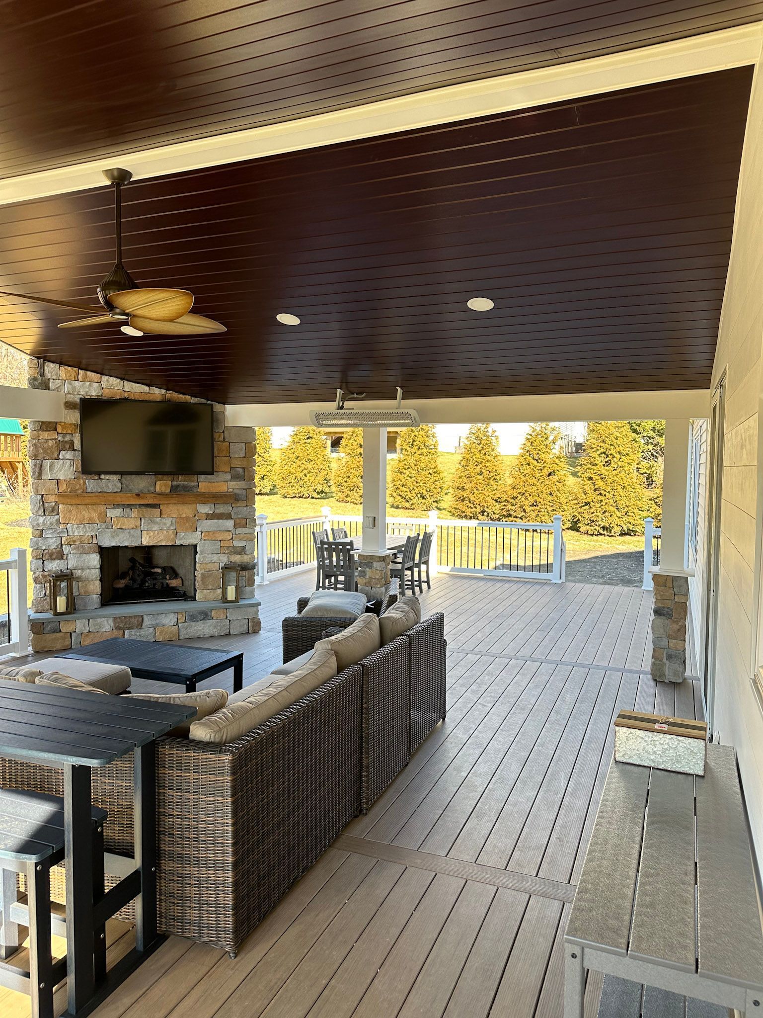 a patio with a fireplace , couch , table and chairs .