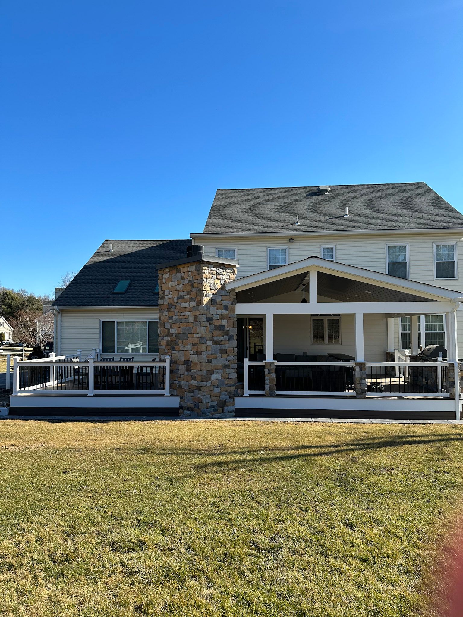 a large white house with a large porch and a stone fireplace .