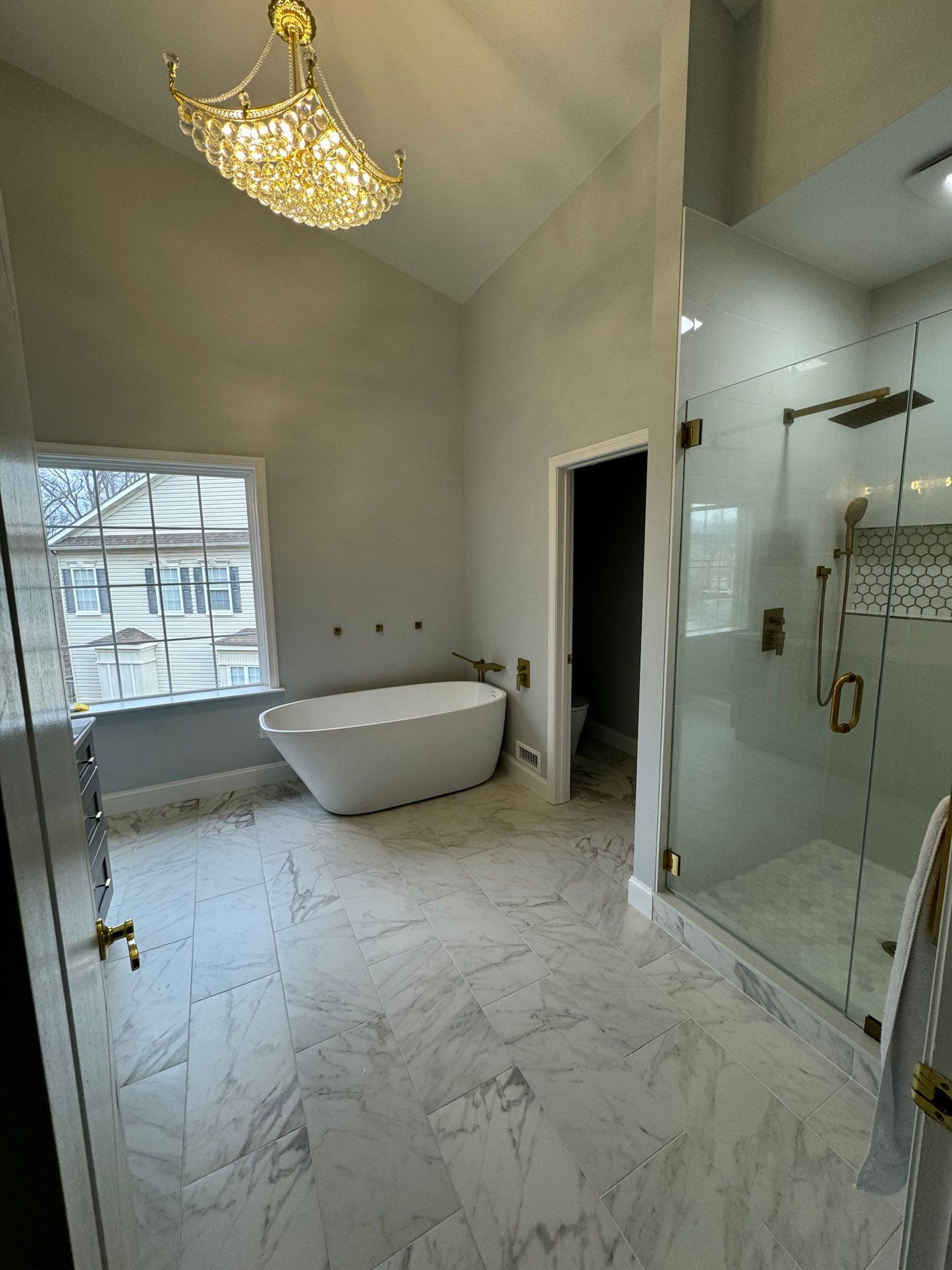 a bathroom with a tub , shower , and window .