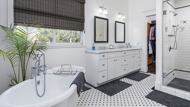 a bathroom with a bathtub , sinks , mirrors and a walk in shower .