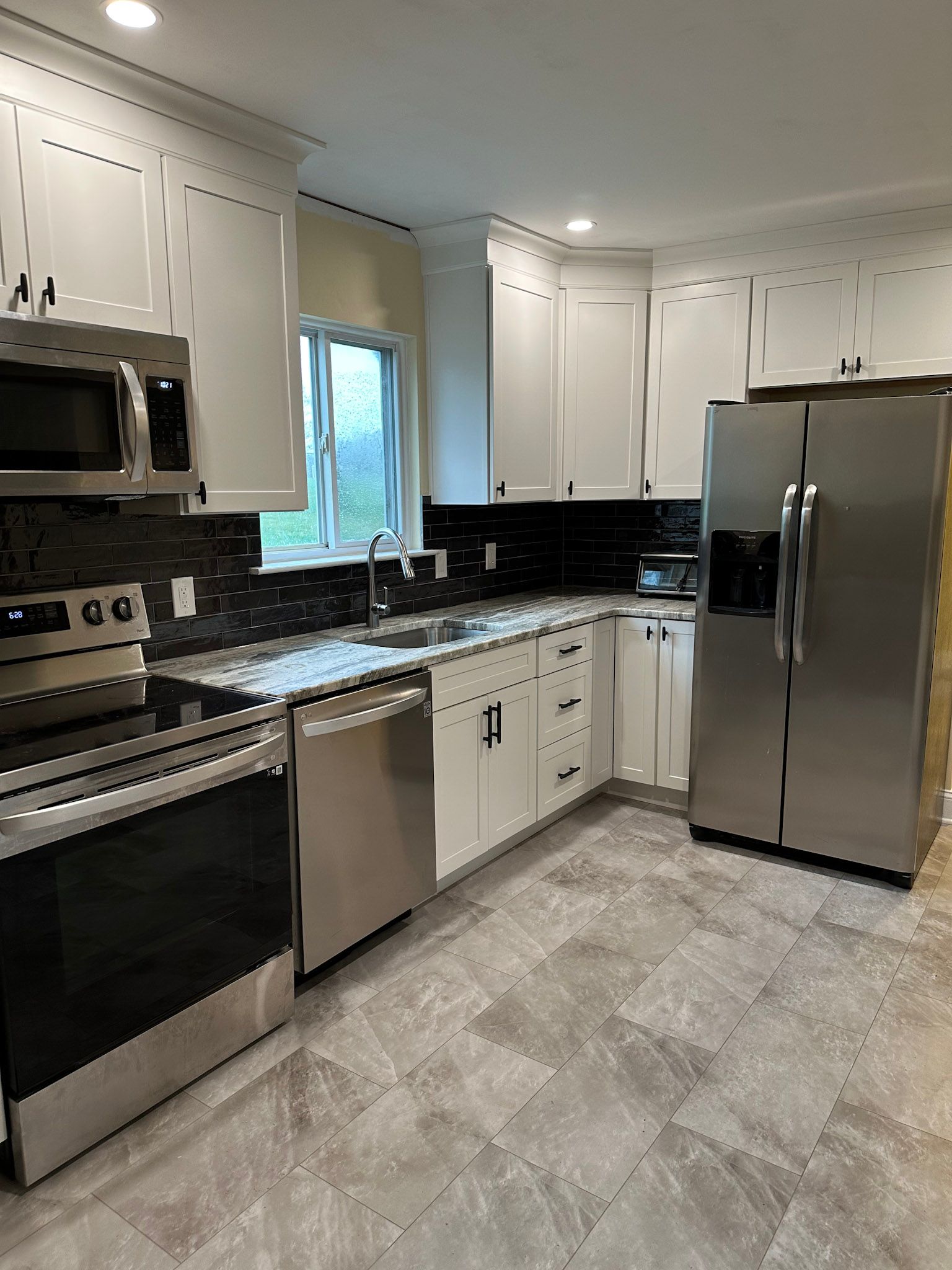 a kitchen with stainless steel appliances and white cabinets .