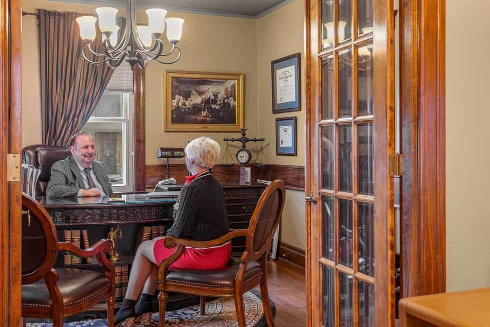 A man and a woman are sitting at a table in a room.