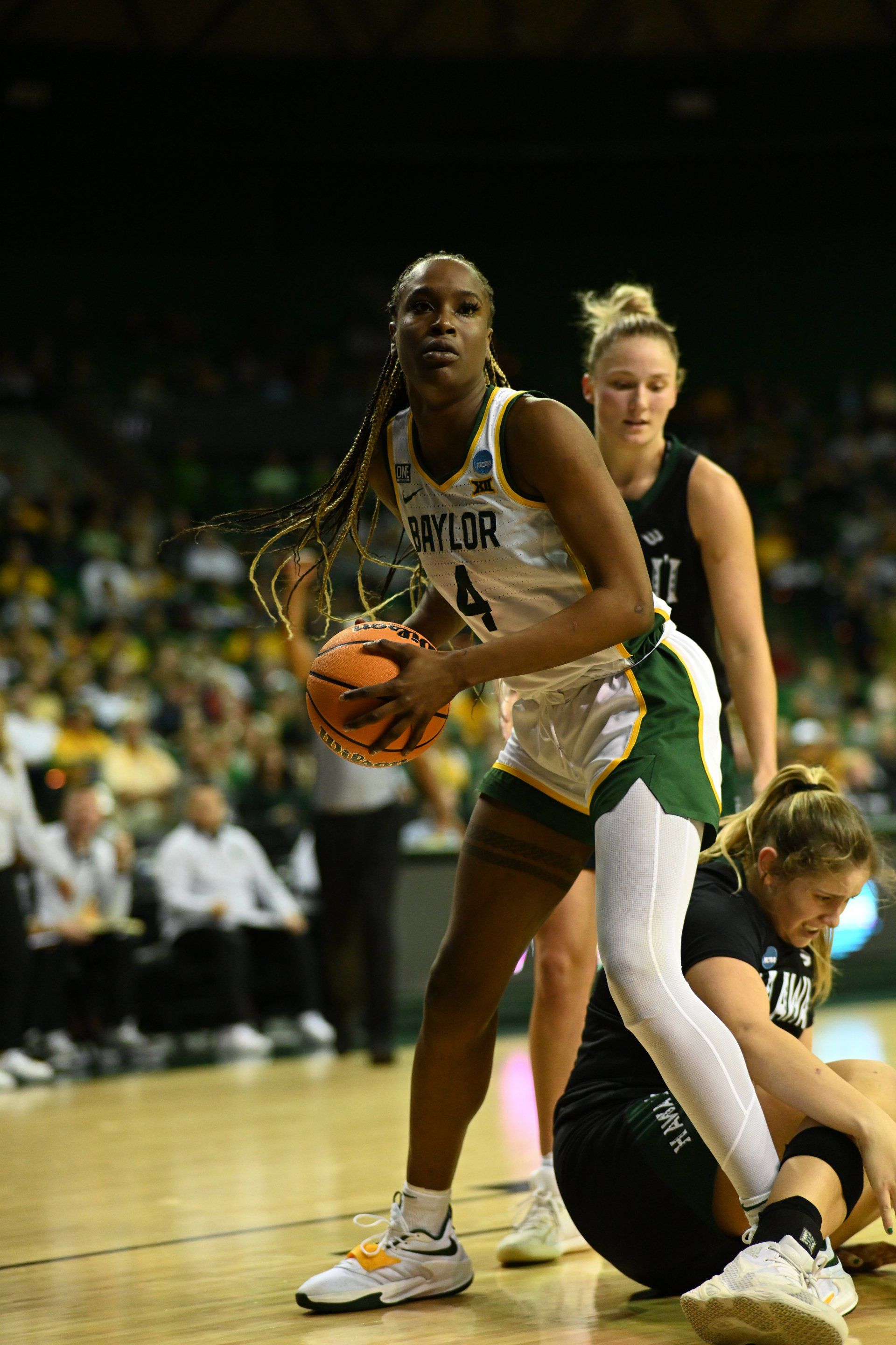 A woman is holding a basketball on a basketball court.