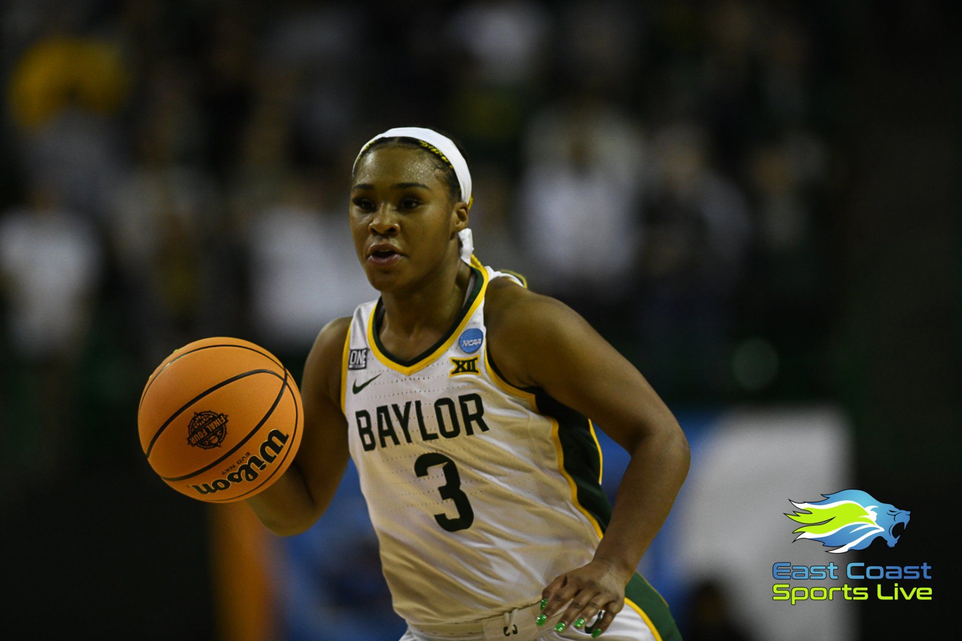 A woman in a baylor jersey is dribbling a basketball