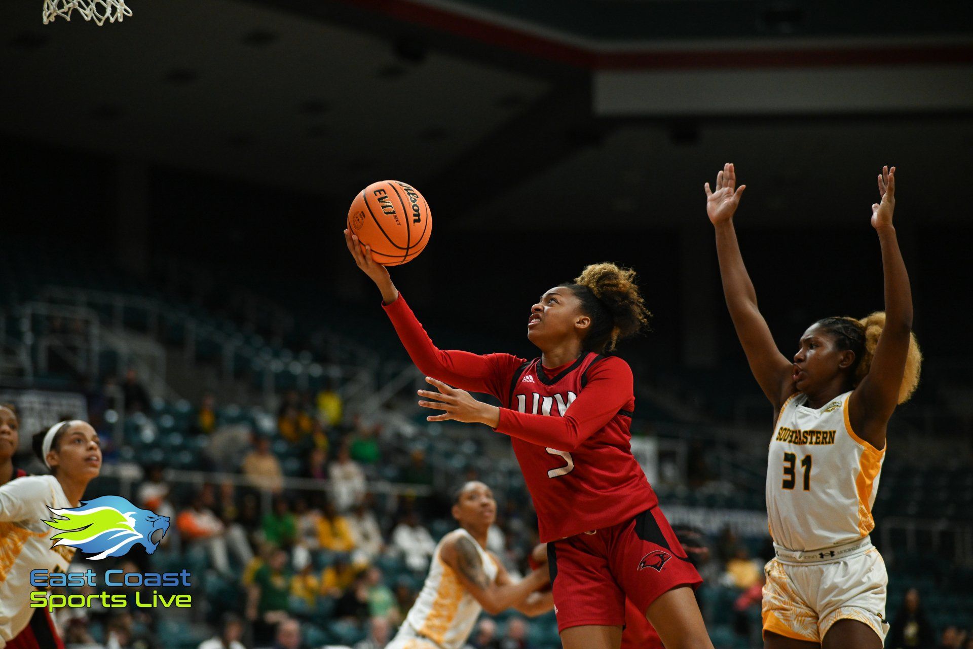 A group of women are playing basketball on a court.