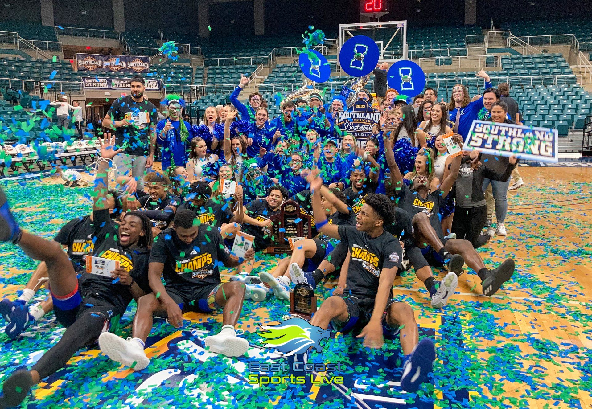 A group of people are posing for a picture on a basketball court.