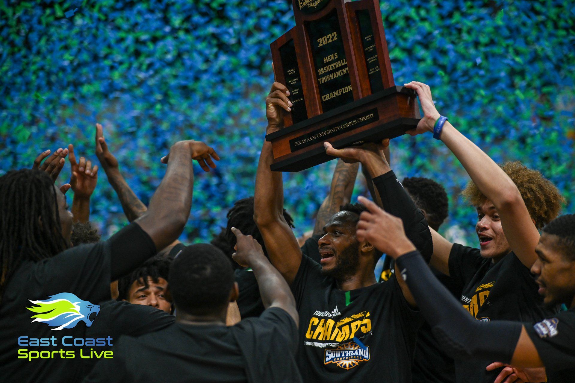 A group of people are holding a trophy in the air.