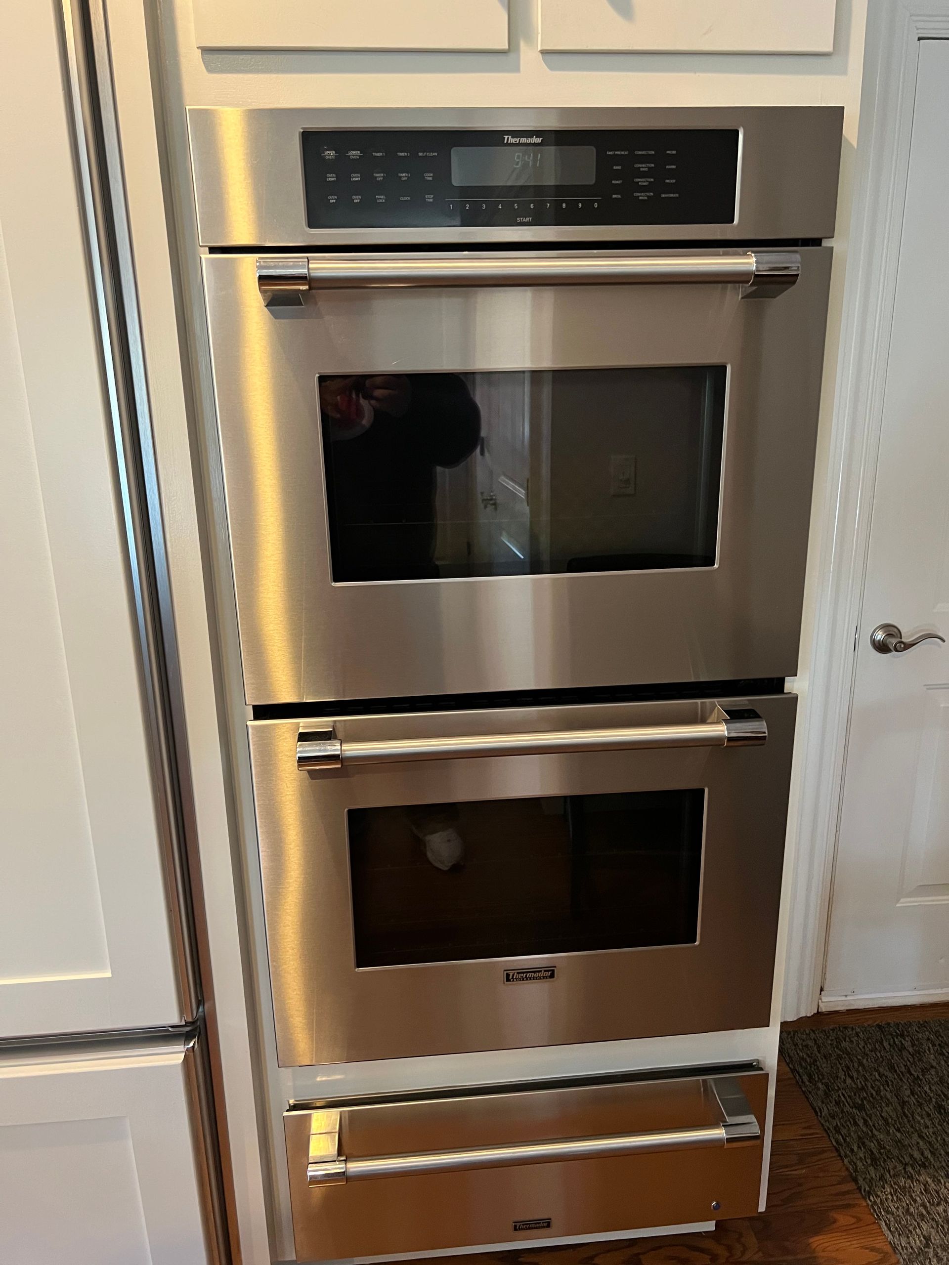 A stainless steel double oven is stacked on top of each other in a kitchen.