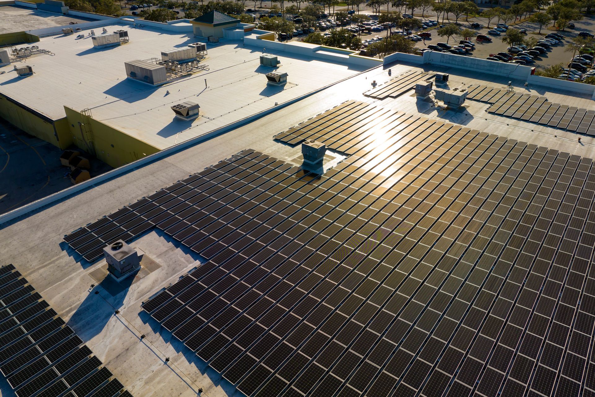 There are many solar panels on the roof of a building.