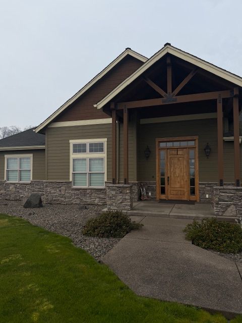 Modern house exterior with stone facade, covered porch, wooden front door, and curved walkway