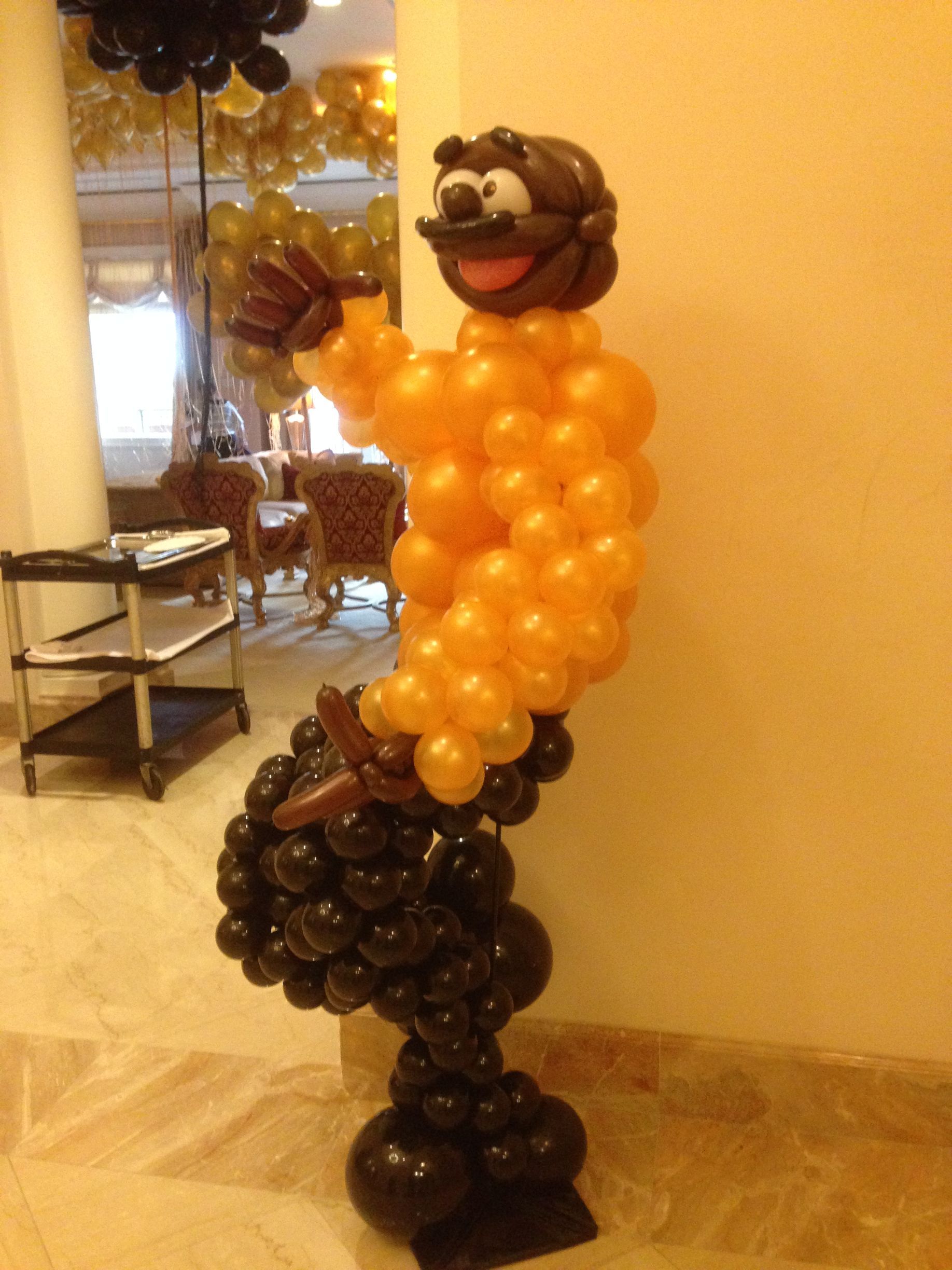 A statue made of balloons is standing in a room