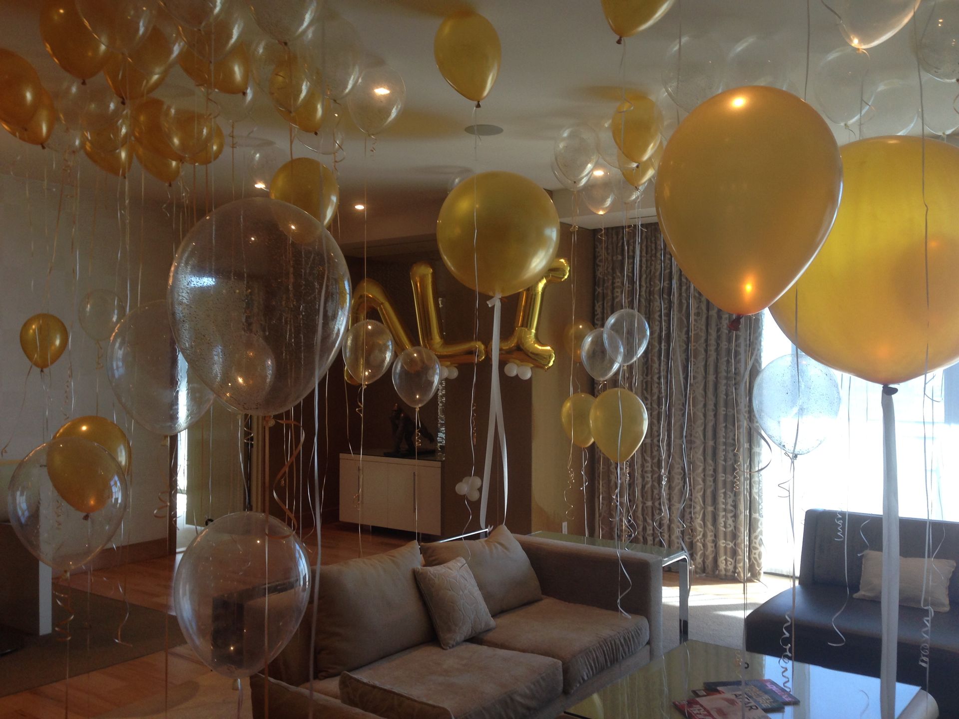 A living room filled with balloons and a couch
