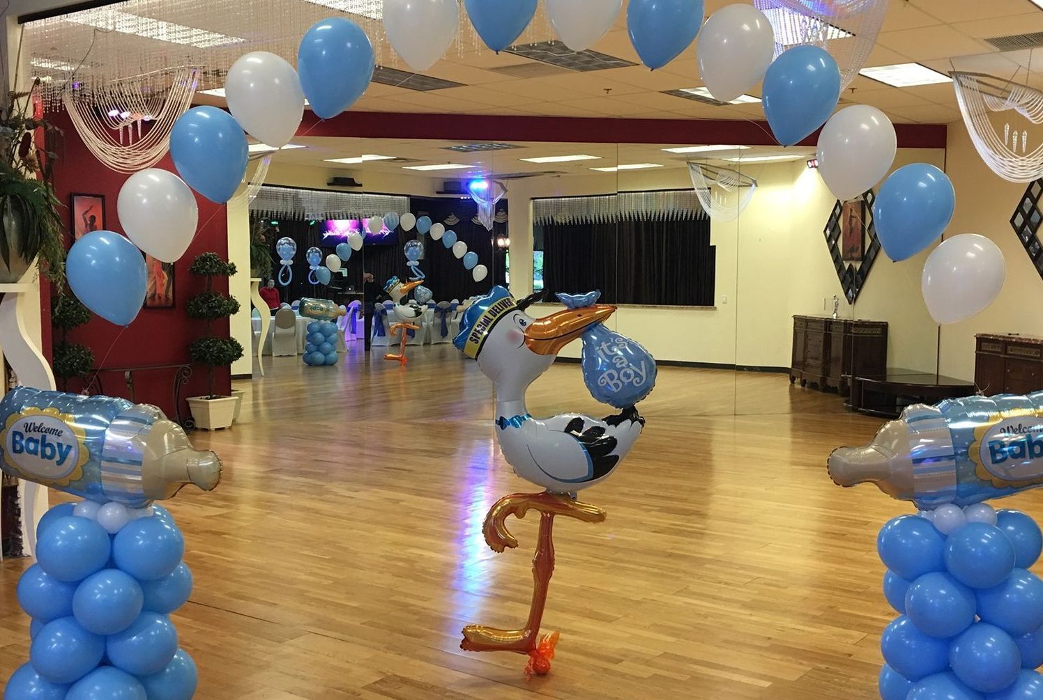 A room decorated with blue and white balloons and a stork balloon