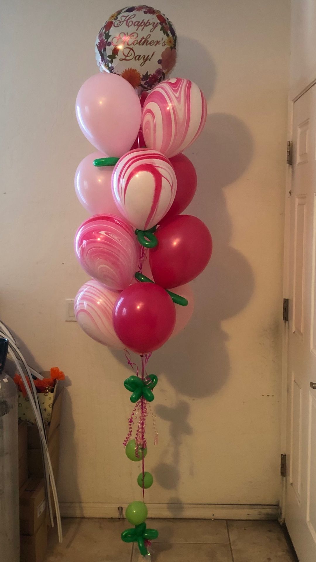 A bunch of pink balloons are sitting on top of each other in a room.