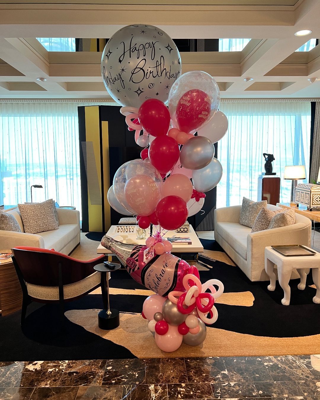 A bunch of balloons are sitting in a living room.