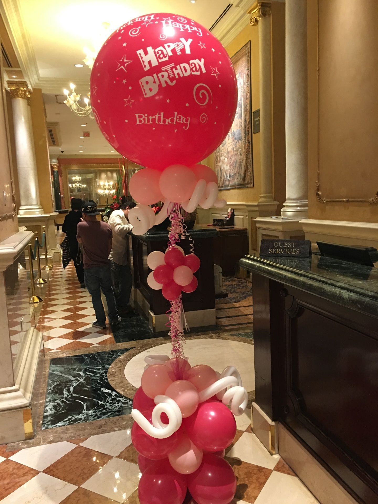 A large red balloon with the words happy birthday written on it