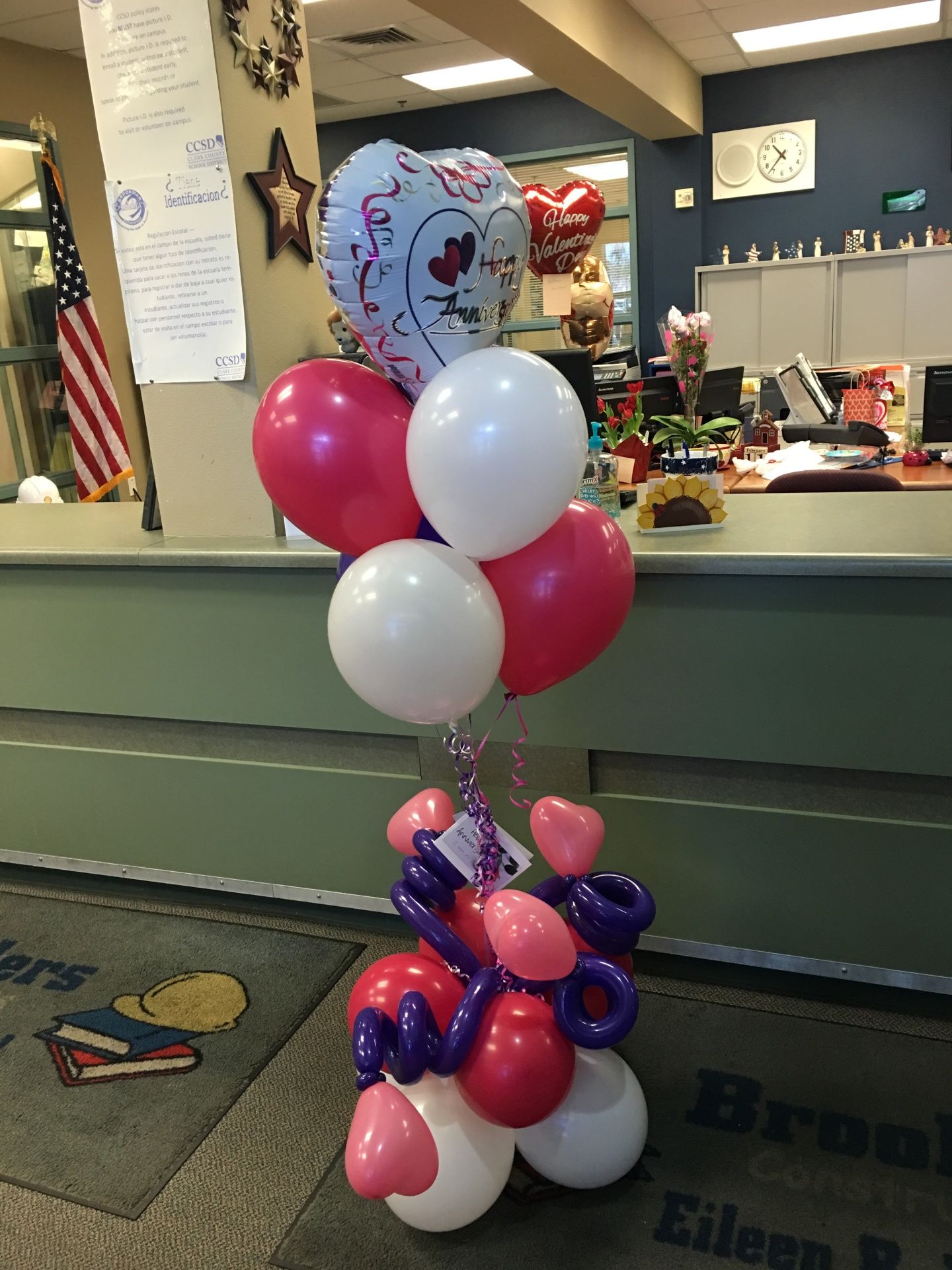 A bunch of pink white and purple balloons on a table