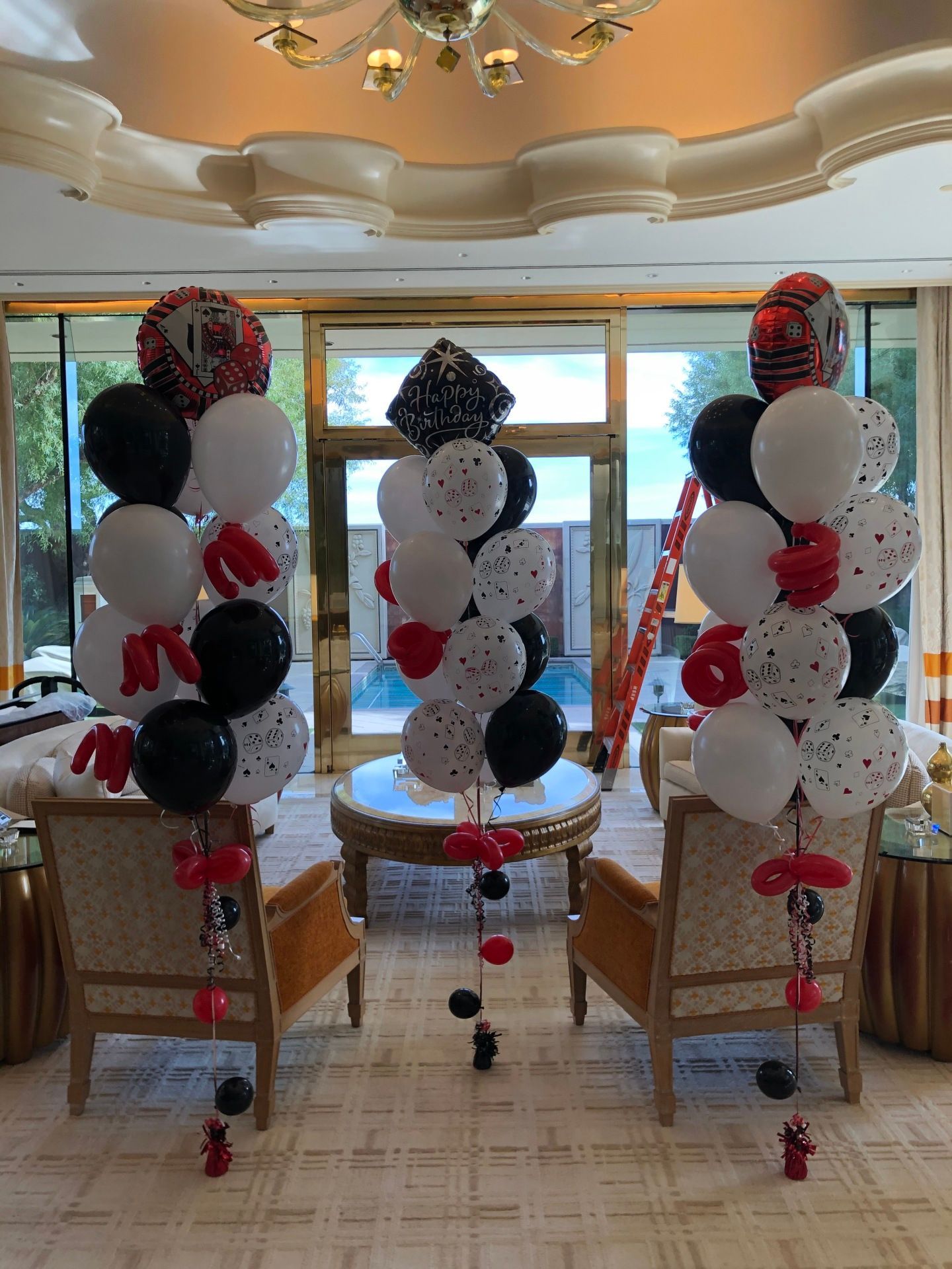 A living room decorated with black , white and red balloons.