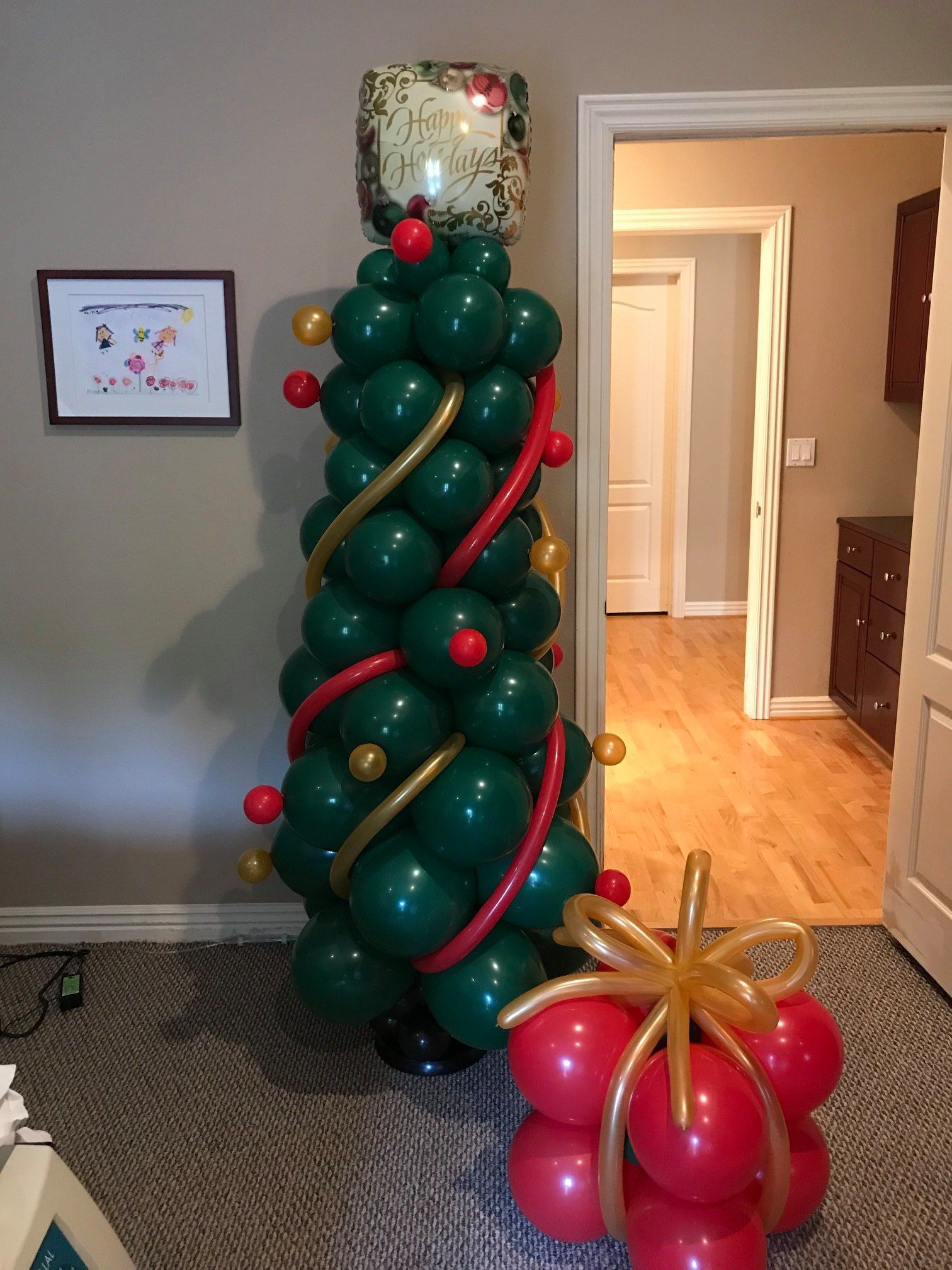 A christmas tree made out of balloons in a living room.