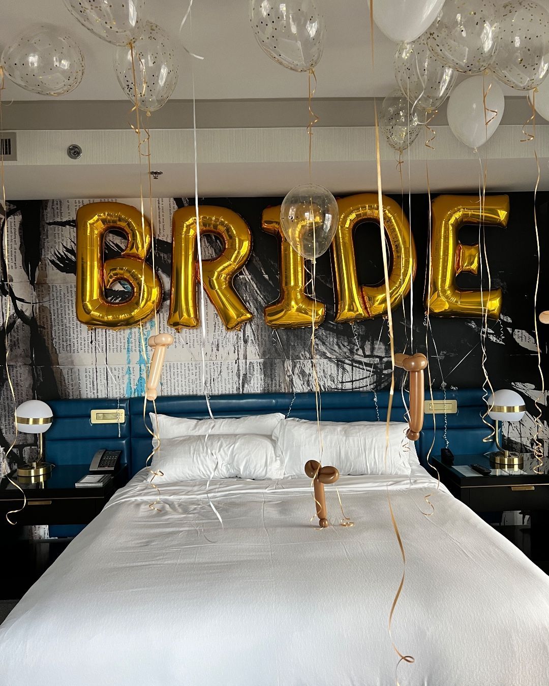 A bedroom with a bed and balloons that say bride