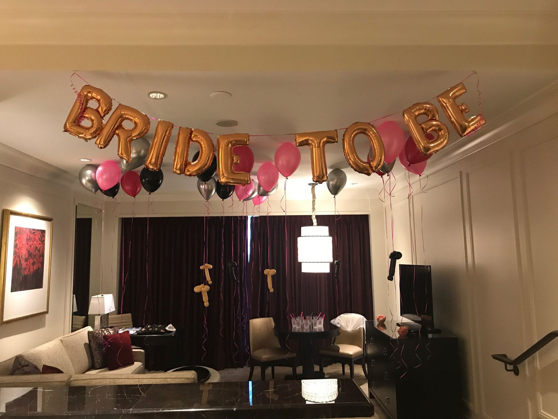A room decorated with balloons and a banner that says `` bride to be ''.