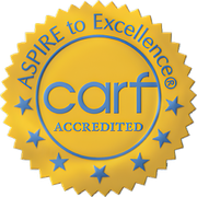 Gold CARF accredited seal with blue stars and “Aspire to Excellence” text