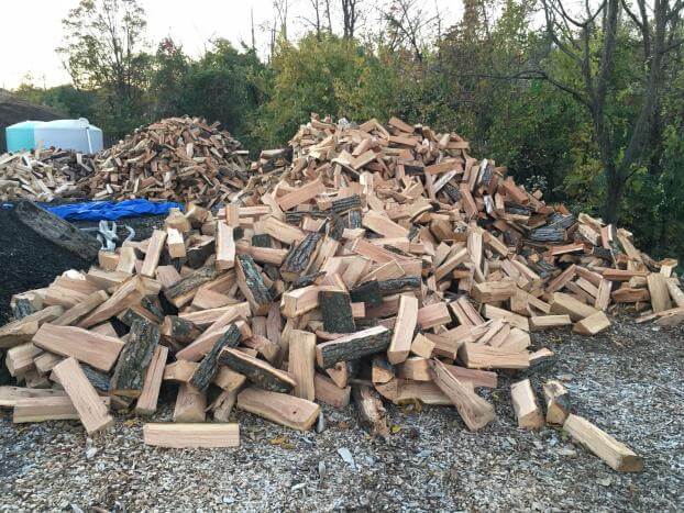 A pile of wood is sitting on top of a gravel road.