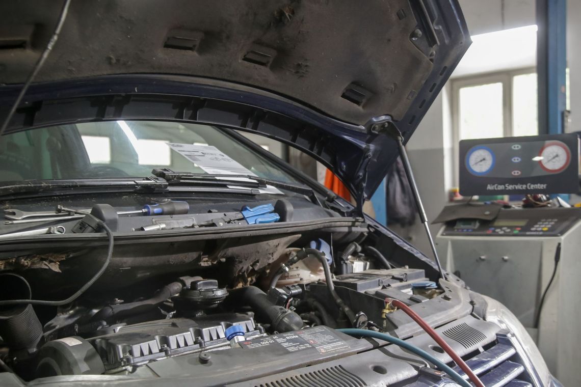 Car engine in a repair shop with the hood open and diagnostic equipment nearby