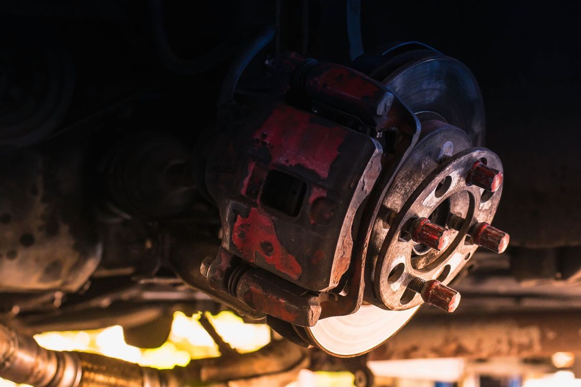 Close-up of a red mechanical brake assembly with glowing sparks beneath it