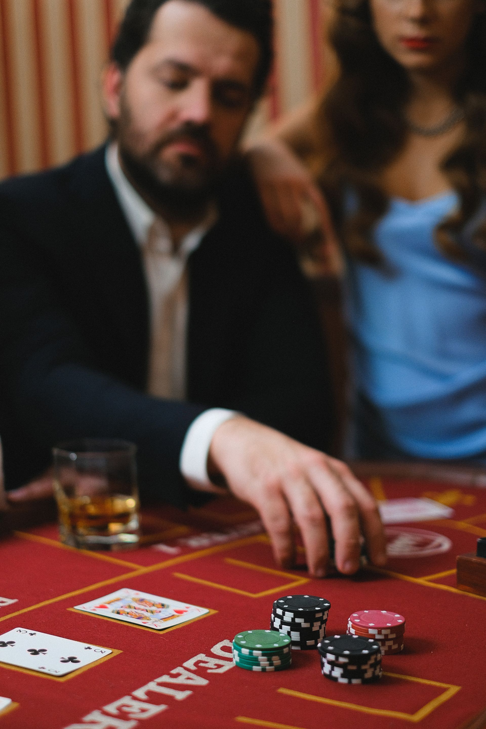 People playing poker at a casino table, with chips and cards in play.