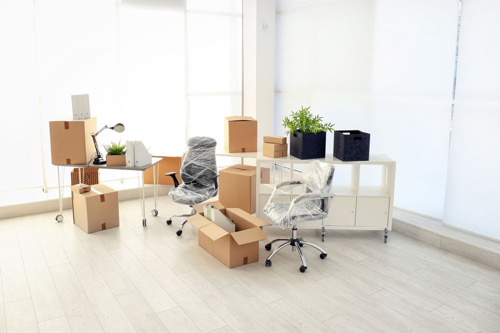 A Room Filled With Boxes , Chairs , Desks and Plants — Davis Removals & Storage in Victoria Point, QLD