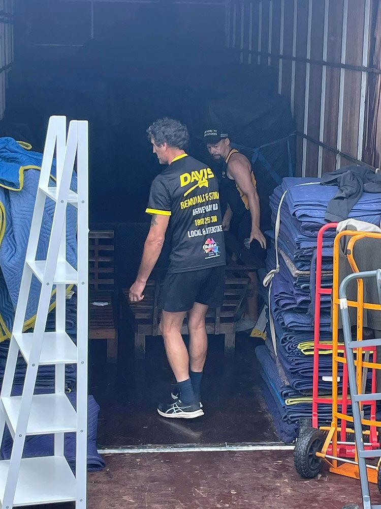 Two Men Are Standing in the Back of a Moving Truck — Davis Removals & Storage in Bundaberg, QLD