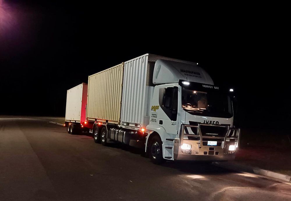 A White Truck is Driving Down a Road at Night — Davis Removals & Storage in Brisbane, QLD