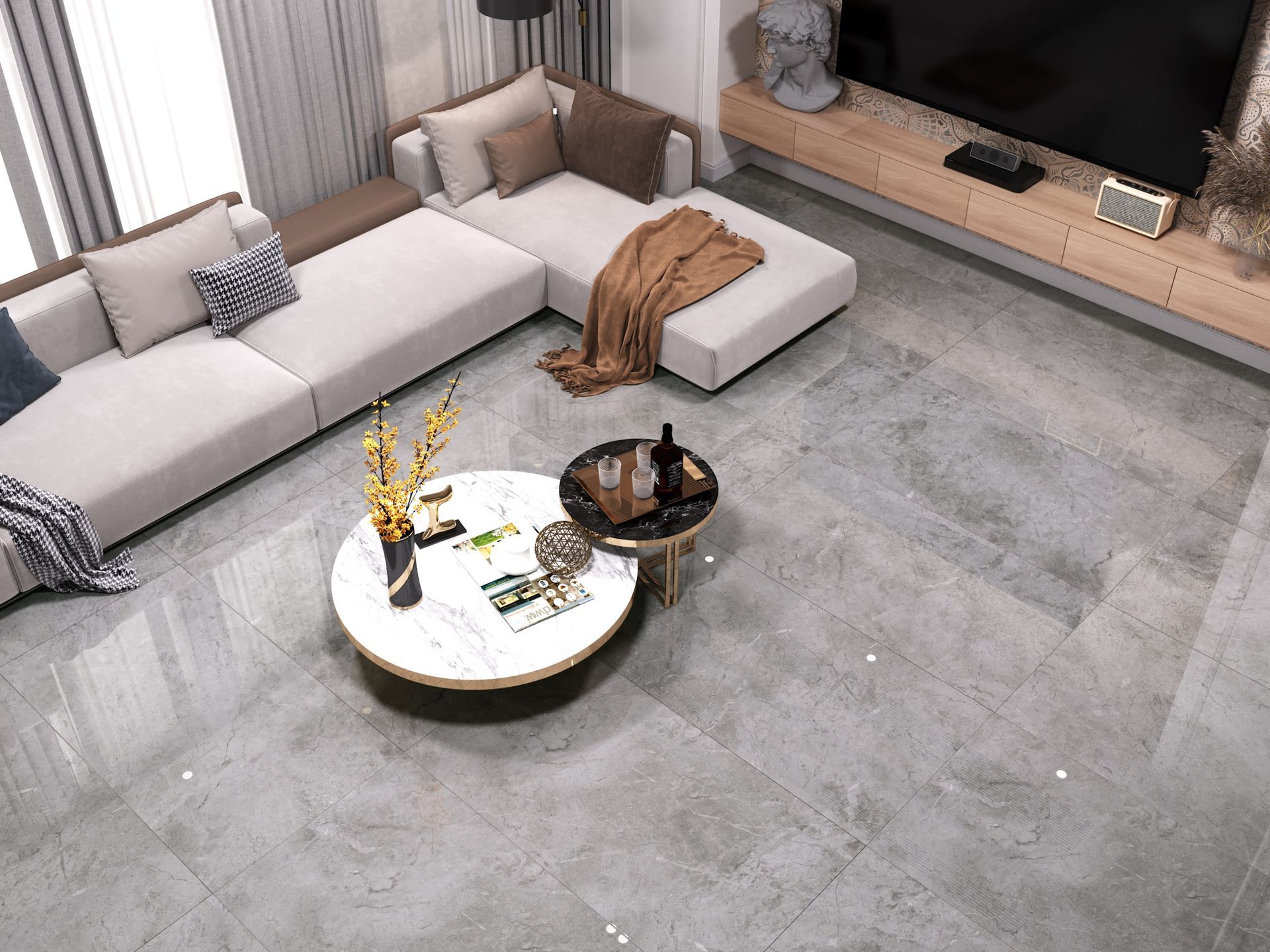 A modern living room with a gray sectional sofa, round coffee table, and large-format gray stone floor tiles.