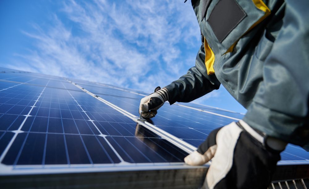 Person Installing Solar Panels on a Rooftop — Gold City Solar & Electrical in Long Flat, QLD